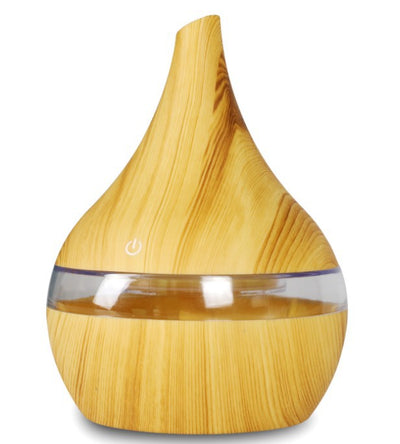 Light wood grain teardrop-shaped mini humidifier and aroma diffuser with a clear water tank and power button. - Image 15