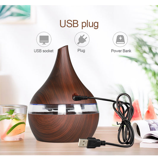 Light wood grain teardrop-shaped mini humidifier and aroma diffuser with a clear water tank and power button. - Image 2