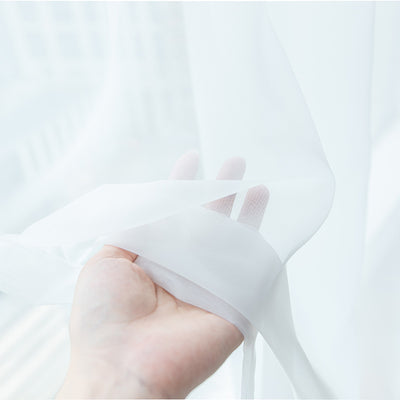Light green sheer curtains hanging on a rod, one tied back, in a modern living room with white walls. - Image 11