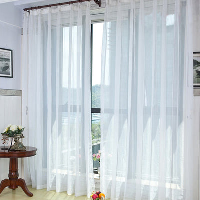 Light green sheer curtains hanging on a rod, one tied back, in a modern living room with white walls. - Image 12