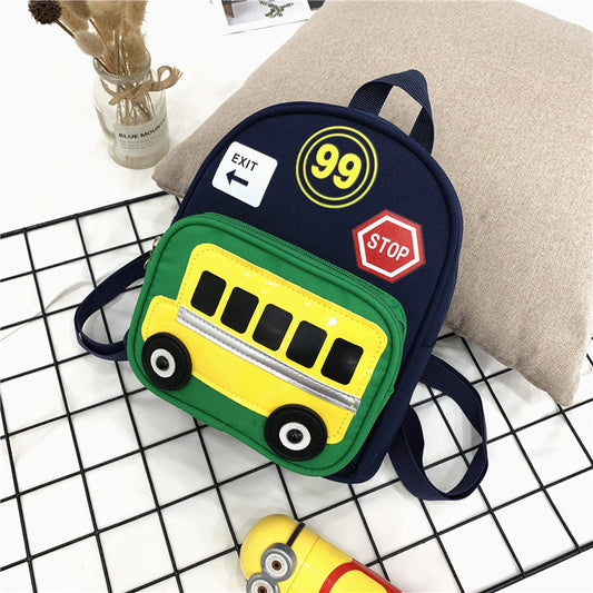 Green mini backpack for kids with a yellow school bus design on the front pocket, 'EXIT', '99', and 'STOP' patches.