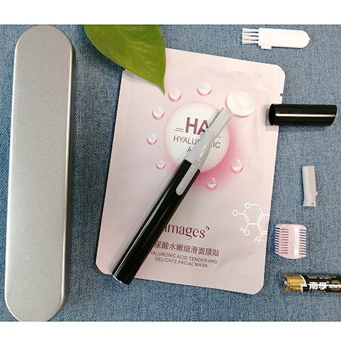 Pink electric shaver with cap off, showing blade, comb attachment, cleaning brush, and AA battery on a pink sheet mask. - Image 6