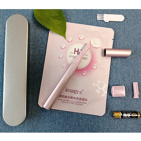 Pink electric shaver with cap off, showing blade, comb attachment, cleaning brush, and AA battery on a pink sheet mask. - Image 5