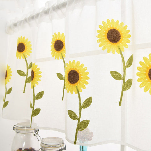 White sheer curtain with embroidered yellow sunflowers and green stems, hanging on a window rod.