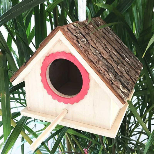 Rustic wooden birdhouse with bark roof, red scalloped entrance, and a hanging rope on a white background. - Image 11