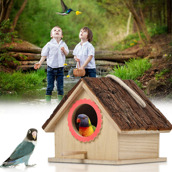 Rustic wooden birdhouse with bark roof, red scalloped entrance, and a hanging rope on a white background.