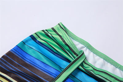 Women's green, blue, and yellow striped two-piece set with a V-neck crop top and an asymmetrical mini skirt. - Image 20
