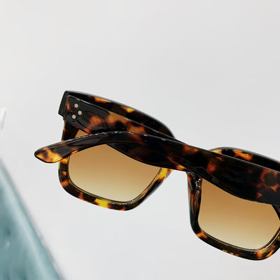 Retro oversized square sunglasses with a dark red frame and pink gradient lenses, held by a hand. - Image 7
