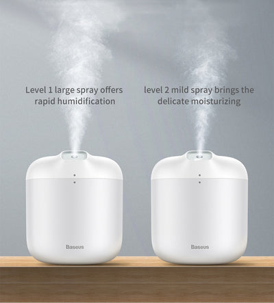 White Baseus car small elephant atomizer actively misting, shown on a wooden surface with a green leaf. - Image 12