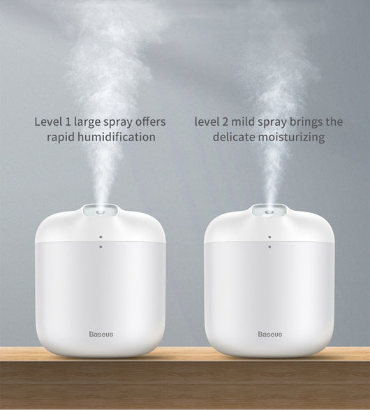 White Baseus car small elephant atomizer actively misting, shown on a wooden surface with a green leaf. - Image 12