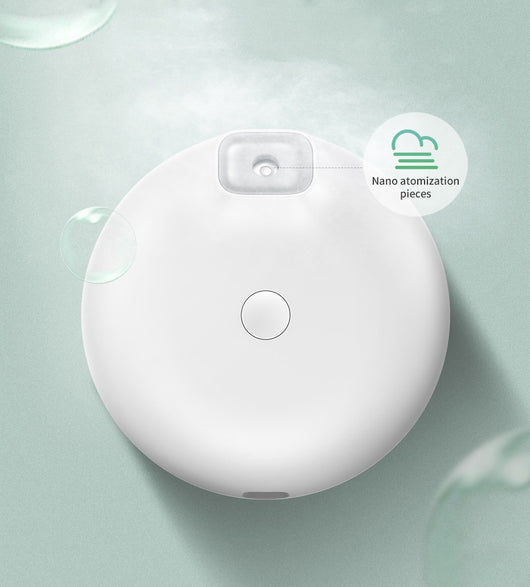 White Baseus car small elephant atomizer actively misting, shown on a wooden surface with a green leaf. - Image 13