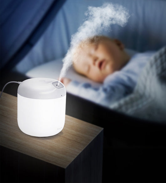 White Baseus car small elephant atomizer actively misting, shown on a wooden surface with a green leaf. - Image 15