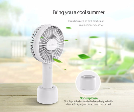White ORICO FH1 handheld USB fan with charging dock, USB cable, and user manuals on a wooden desk. - Image 9