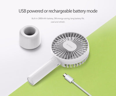 White ORICO FH1 handheld USB fan with charging dock, USB cable, and user manuals on a wooden desk. - Image 10