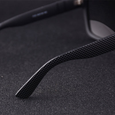 Men's grey plastic frame driving sunglasses with dark polarized lenses and red and black stripe detail on temples. - Image 24
