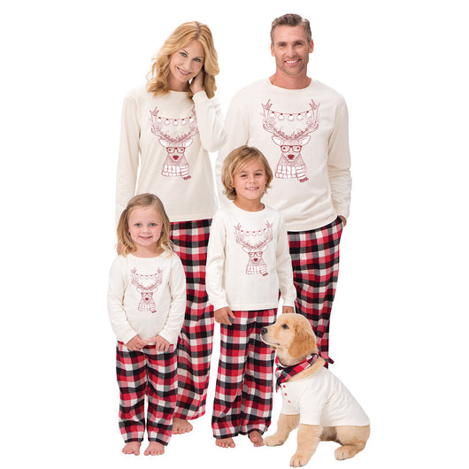 Child wearing a cream long-sleeve pajama top with a reindeer graphic and red, black, and white plaid pajama pants. - Image 5