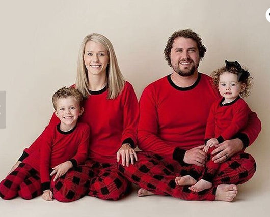 Family of four wearing matching red and black buffalo plaid Christmas pajamas, featuring solid red long-sleeve tops and plaid pants. - Image 10