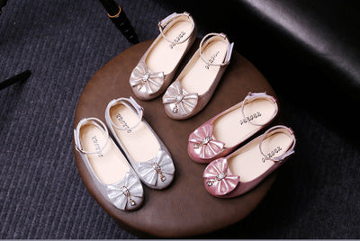 Shiny pink children's ballet flats with ankle straps, decorative bows, and rhinestone embellishments. - Image 7