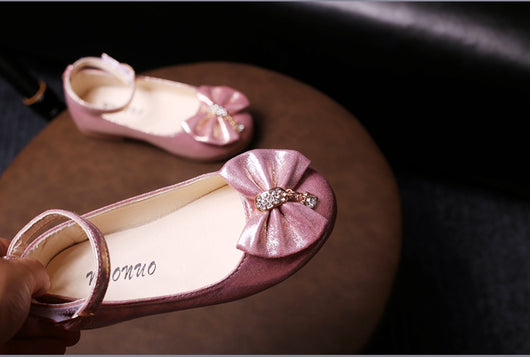 Shiny pink children's ballet flats with ankle straps, decorative bows, and rhinestone embellishments. - Image 18
