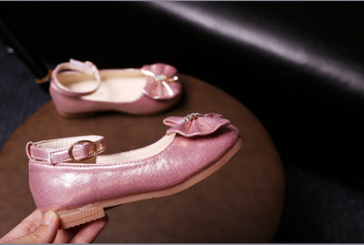 Shiny pink children's ballet flats with ankle straps, decorative bows, and rhinestone embellishments. - Image 19