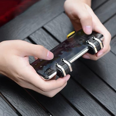 Black and silver mobile gaming trigger controller attached to a silver smartphone, showing the left button and game screen. - Image 11