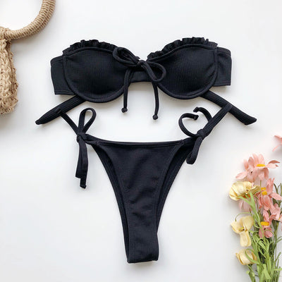 Light pink ribbed bikini set with a strapless ruffled top and high-cut, tie-side bottom on a model. - Image 7