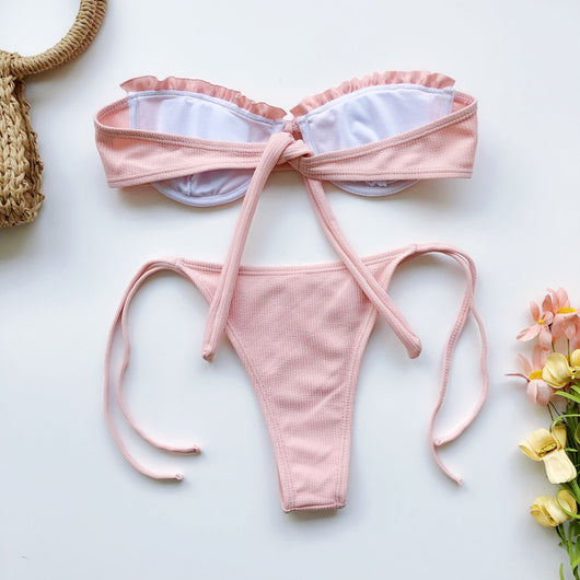 Light pink ribbed bikini set with a strapless ruffled top and high-cut, tie-side bottom on a model. - Image 13