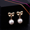 Aretes Elegantes de Corazón con Moño de Circonia y Perla