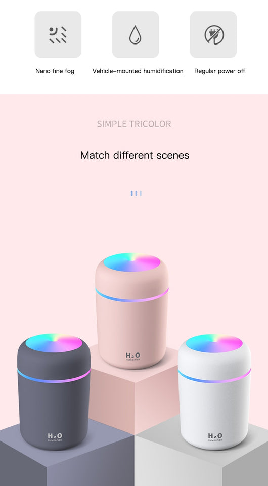Dark gray cylindrical humidifier with colorful LED top light and thin light band, shown with five white filter sticks. - Image 10