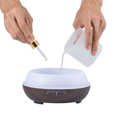 Wood grain ultrasonic aromatherapy diffuser and humidifier with a glowing blue LED light band and control buttons. - Image 20