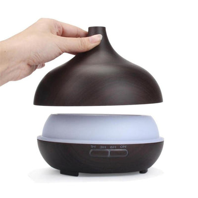 Wood grain ultrasonic aromatherapy diffuser and humidifier with a glowing blue LED light band and control buttons. - Image 18