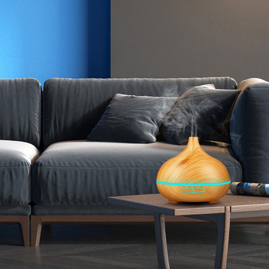 Wood grain ultrasonic aromatherapy diffuser and humidifier with a glowing blue LED light band and control buttons. - Image 11
