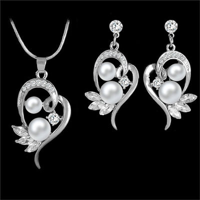 Gold-toned heart-shaped necklace and dangle earrings set with clear rhinestones and faux pearls. - Image 16