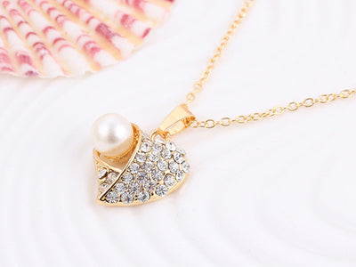 Gold-toned heart-shaped necklace and dangle earrings set with clear rhinestones and faux pearls. - Image 25