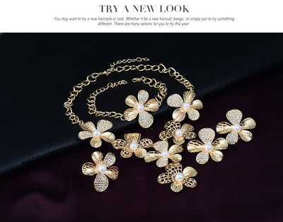 Gold-tone four-piece jewelry set with flower motifs, featuring a necklace, bracelet, ring, and earrings, all with faux pearls and clear rhinestones. - Image 9