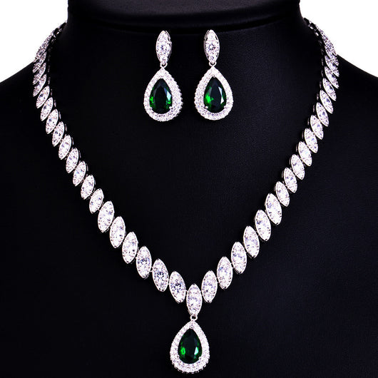 Silver-toned necklace and earring set with red teardrop stones and clear marquise-cut accents on a black display. - Image 10