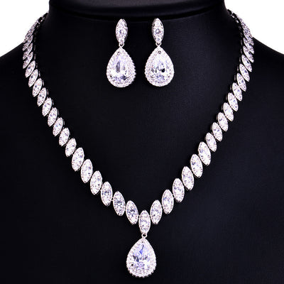 Silver-toned necklace and earring set with red teardrop stones and clear marquise-cut accents on a black display. - Image 11