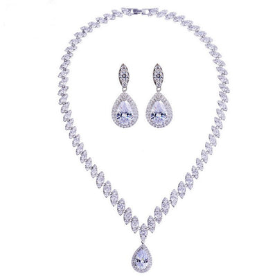 Silver-toned necklace and earring set with red teardrop stones and clear marquise-cut accents on a black display. - Image 14