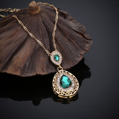 Gold-toned necklace and matching drop earrings set with blue teardrop crystals and clear rhinestones, on a wooden box. - Image 20