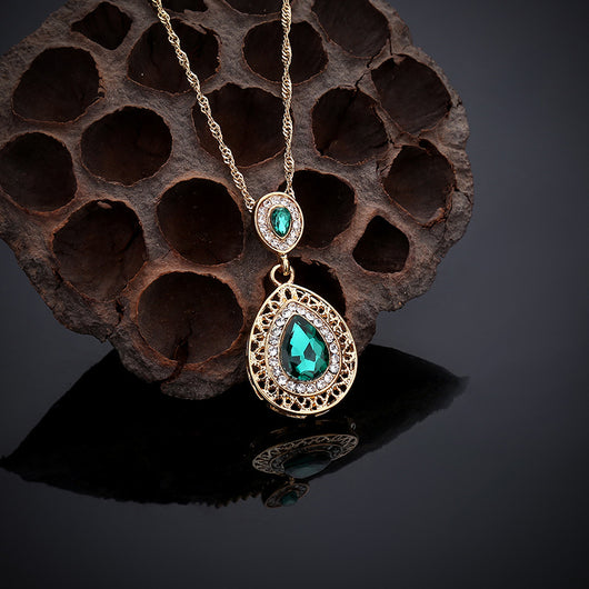 Gold-toned necklace and matching drop earrings set with blue teardrop crystals and clear rhinestones, on a wooden box. - Image 21