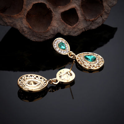 Gold-toned necklace and matching drop earrings set with blue teardrop crystals and clear rhinestones, on a wooden box. - Image 23