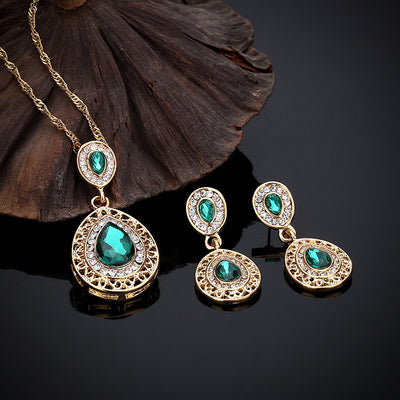 Gold-toned necklace and matching drop earrings set with blue teardrop crystals and clear rhinestones, on a wooden box. - Image 24
