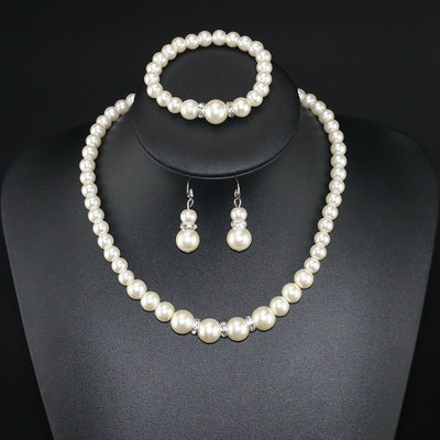Three-piece cream faux pearl jewelry set with rhinestone accents, including a necklace, bracelet, and drop earrings. - Image 2