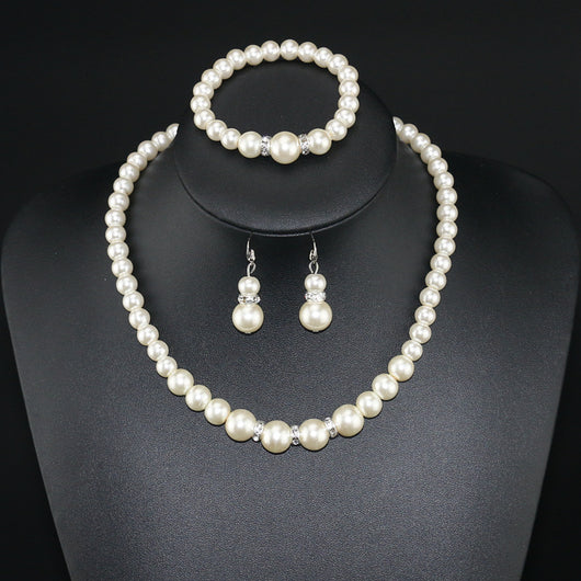 Three-piece cream faux pearl jewelry set with rhinestone accents, including a necklace, bracelet, and drop earrings. - Image 2