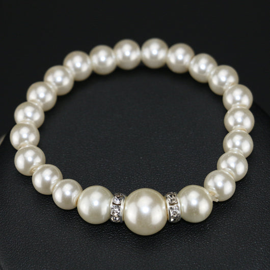 Three-piece cream faux pearl jewelry set with rhinestone accents, including a necklace, bracelet, and drop earrings. - Image 3