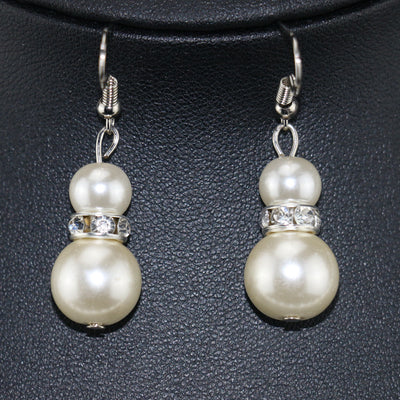 Three-piece cream faux pearl jewelry set with rhinestone accents, including a necklace, bracelet, and drop earrings. - Image 4