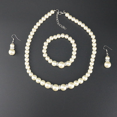 Three-piece cream faux pearl jewelry set with rhinestone accents, including a necklace, bracelet, and drop earrings. - Image 5
