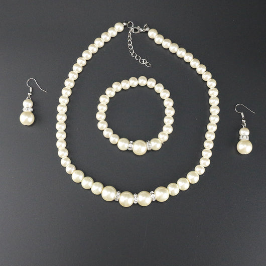 Three-piece cream faux pearl jewelry set with rhinestone accents, including a necklace, bracelet, and drop earrings. - Image 5