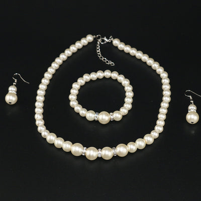 Three-piece cream faux pearl jewelry set with rhinestone accents, including a necklace, bracelet, and drop earrings. - Image 6