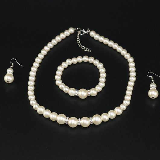 Three-piece cream faux pearl jewelry set with rhinestone accents, including a necklace, bracelet, and drop earrings. - Image 6